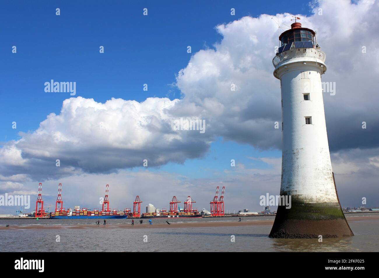 New Brighton Lighthouse with views across the River Mersey to Liverpool Docks and Liverpool2 Container Cranes Stock Photo