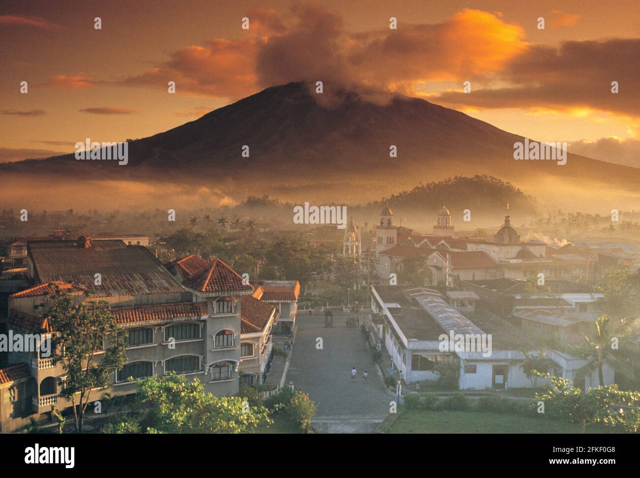 Philippines. Luzon Island. Early morning view of volcano and Spanish colonial buildings. Stock Photo