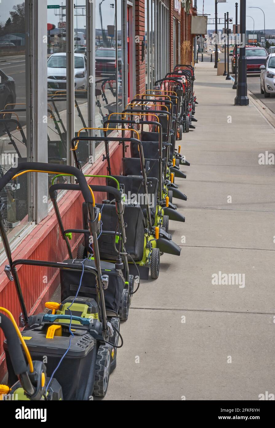 Lawn mowers on the sidewalk outside of a hardware store Stock Photo Alamy