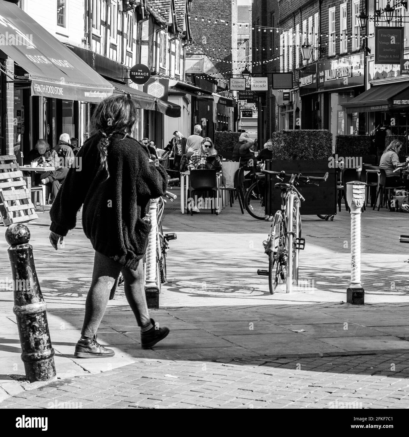 Kingston Upon Thames, London UK, April 2021, Woman Walking Past People Sitting Outside Eating And Drinking Stock Photo