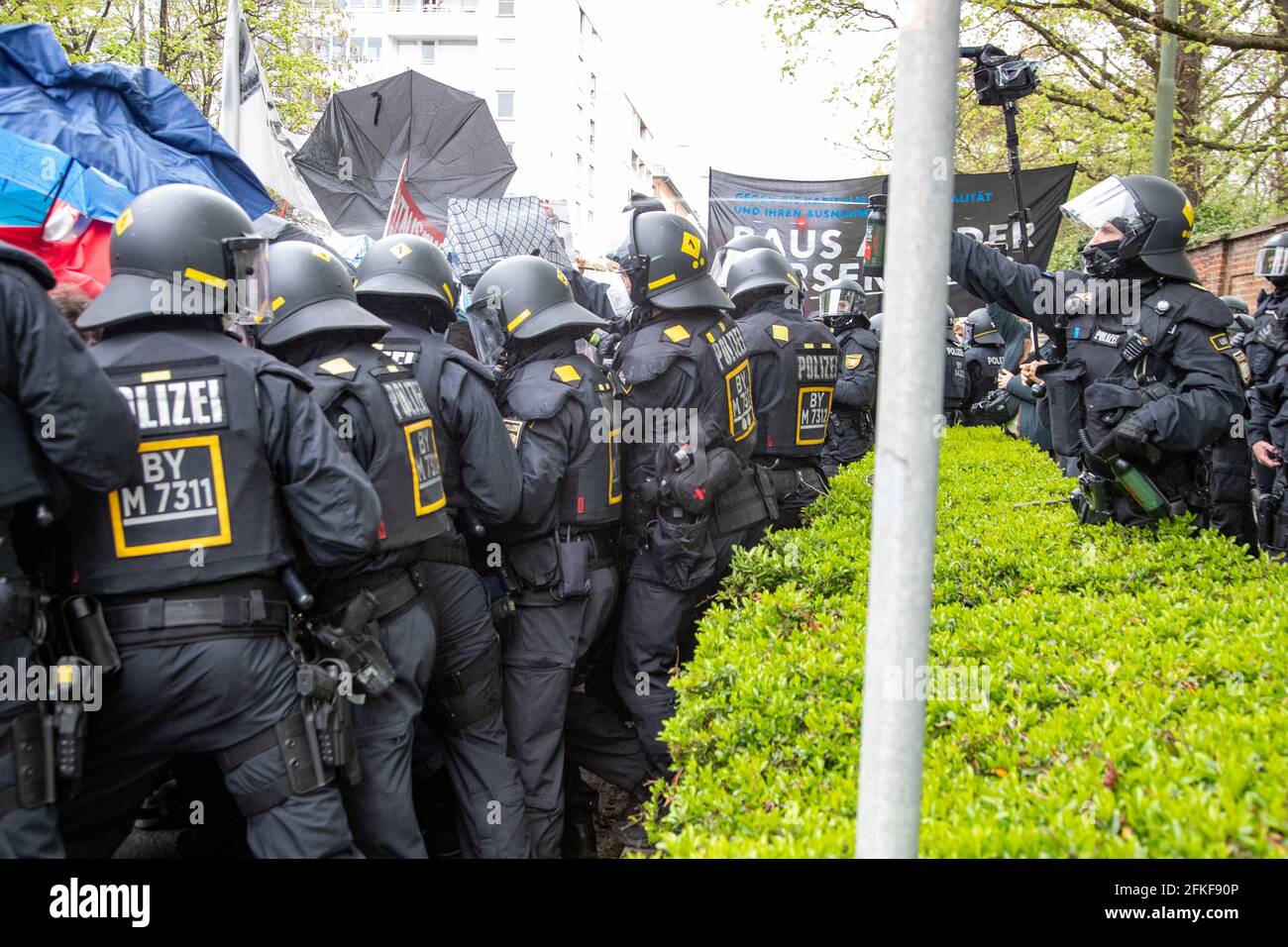Polizist benutzt Pfefferspray. Hunderte Menschen versammelten sich am 1.  Mai 2021 zur revolutionären 1. Mai Demo in München. Es kam wiederholt zu  Anspannungen zwischen Polizei und Demonstrant*innen sowie auch zu kleineren  Auseinandersetzungen