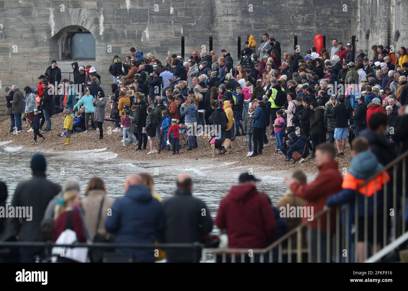 People line the shore of the Hot Walls as they wait for the Royal Navy Aircraft carrier HMS Queen Elizabeth to leave Portsmouth Naval Base in Hampshire for exercises off Scotland before heading to the Indo-Pacific region. Picture date: Saturday May 1, 2021. Stock Photo