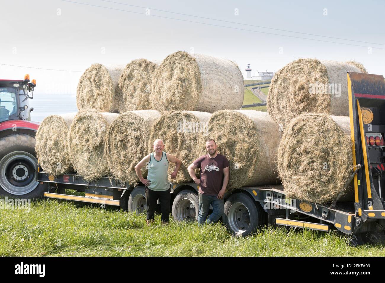 Galley Head, Cork, Ireland. 01st May, 2021.Farmer Ger Deasy with contractor Jonathan Crowley saving organic hay on May Day at the Galley Head in West Cork, Ireland. - Credit; David Creedon / Alamy Live News Stock Photo