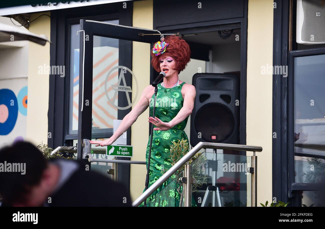 Brighton UK 1st May 2021 - A drag queen entertains outside a Brighton seafront bar as people enjoy the May Bank Holiday weekend with things gradually getting back to normal in England with lockdown restrictions allowing hospitality venues to serve drink outdoors : Credit Simon Dack / Alamy Live News Stock Photo