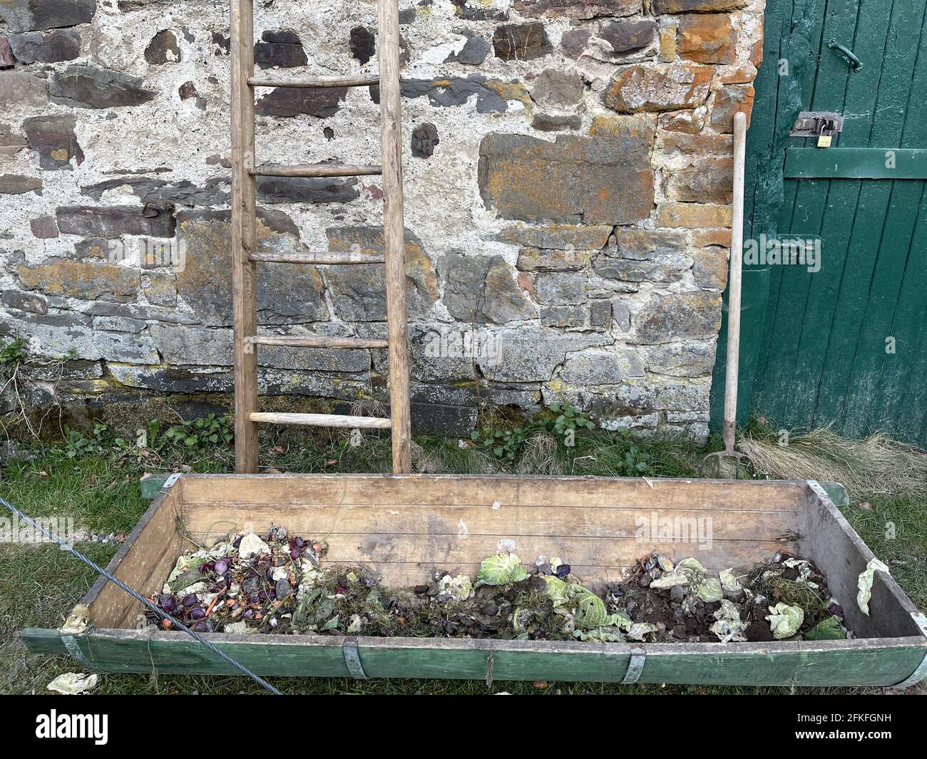 Wooden staircase and an old garden bed with vegetable waste and soil in