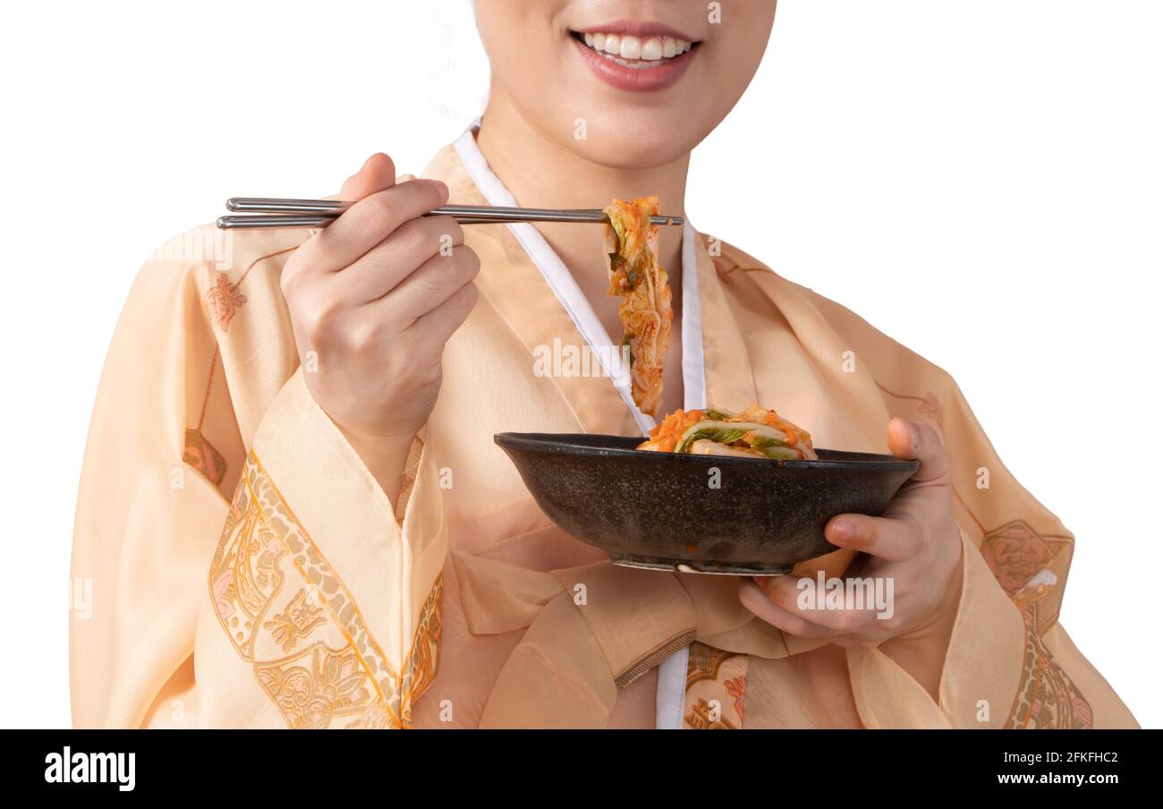 Asian Women wearing Korean Hanbok, holding Kimchi bowl and eating