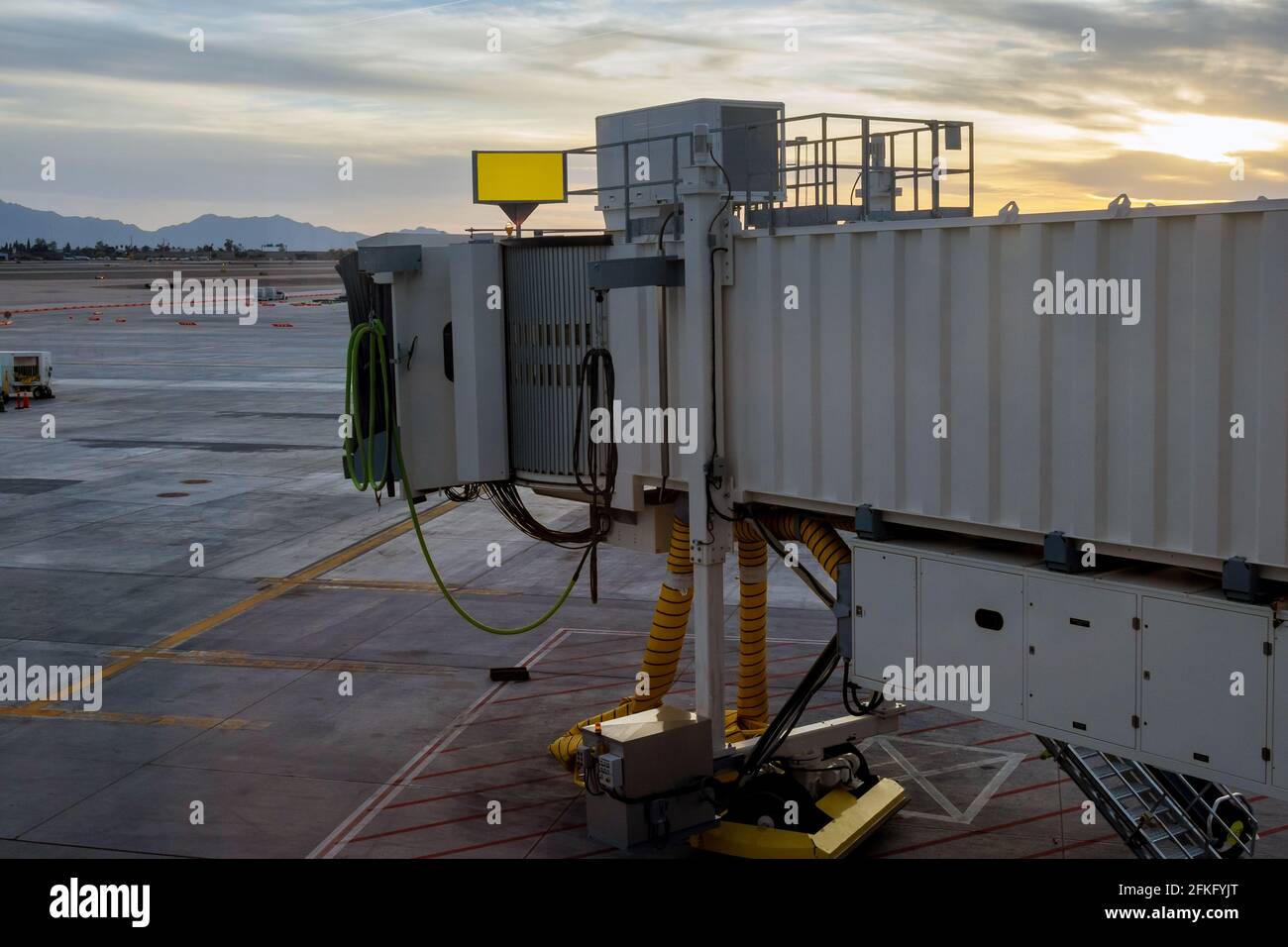 Plane taking off into red sunset in boarding bridge used to connect