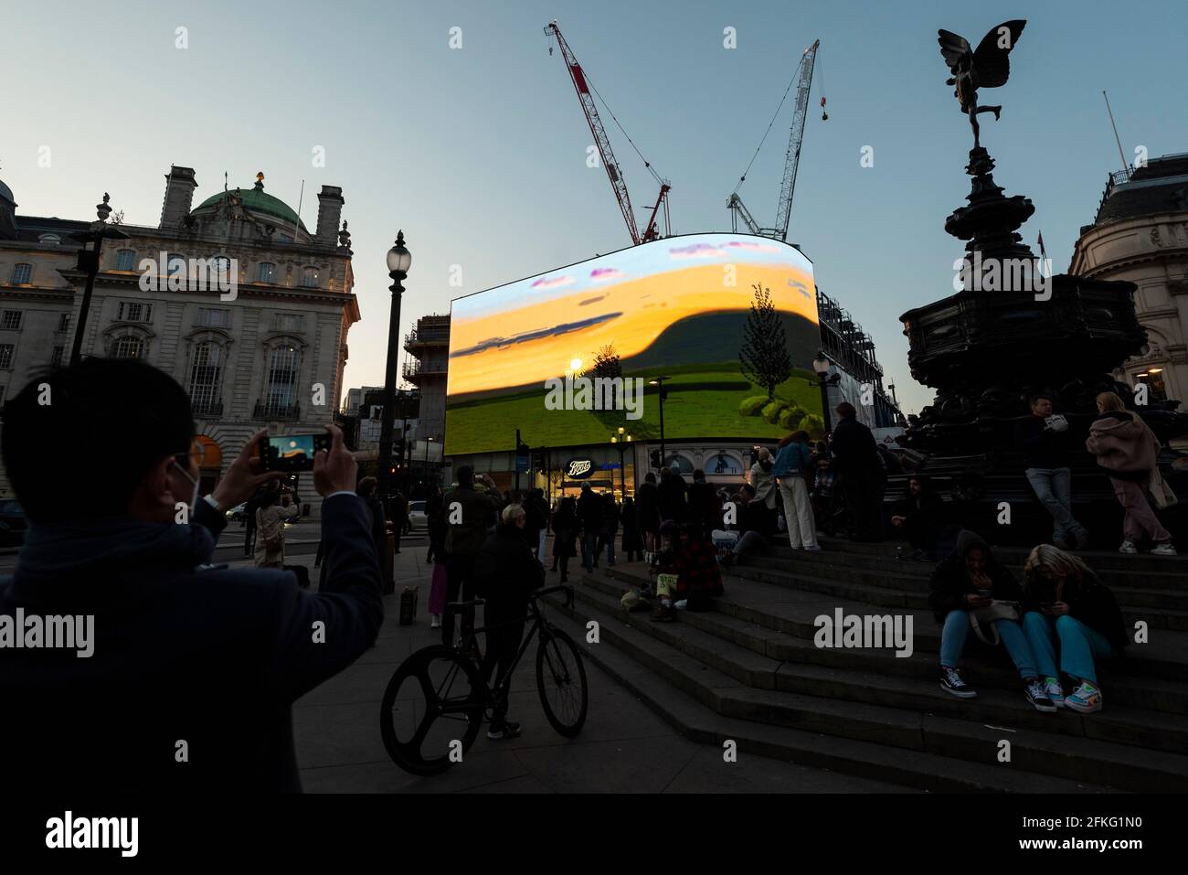 London, UK.  1 May 2021.  David Hockney’s “Remember You Cannot Look At The Sun Or Death For Very Long” artwork, showing an animated sunrise, is displayed on the giant screens at Piccadilly Circus.  It will also be displayed on screens in other cities worldwide.  The work, created on an iPad, is supposed to offer a symbol of hope as the world awakens from its long lockdown and also coincides with his upcoming “The Arrival of Spring” exhibition at the Royal Academy.  In London, the work is on display nightly for the month of May.  Credit: Stephen Chung / Alamy Live News Stock Photo