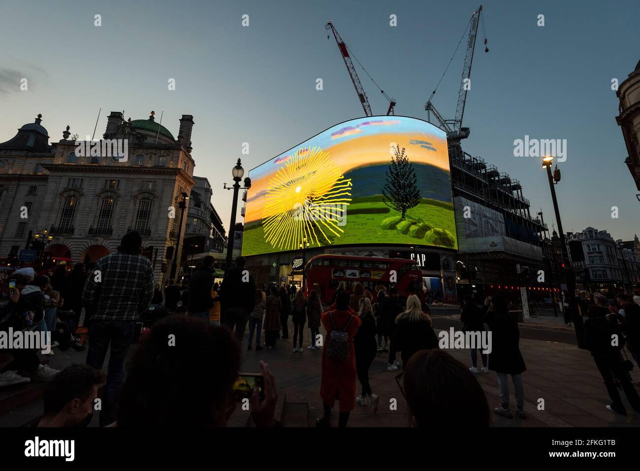 London, UK.  1 May 2021.  David Hockney’s “Remember You Cannot Look At The Sun Or Death For Very Long” artwork, showing an animated sunrise, is displayed on the giant screens at Piccadilly Circus.  It will also be displayed on screens in other cities worldwide.  The work, created on an iPad, is supposed to offer a symbol of hope as the world awakens from its long lockdown and also coincides with his upcoming “The Arrival of Spring” exhibition at the Royal Academy.  In London, the work is on display nightly for the month of May.  Credit: Stephen Chung / Alamy Live News Stock Photo