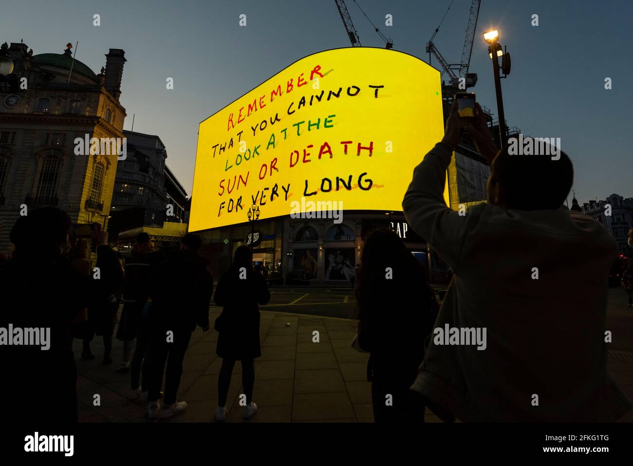 London, UK.  1 May 2021.  David Hockney’s “Remember You Cannot Look At The Sun Or Death For Very Long” artwork, showing an animated sunrise, is displayed on the giant screens at Piccadilly Circus.  It will also be displayed on screens in other cities worldwide.  The work, created on an iPad, is supposed to offer a symbol of hope as the world awakens from its long lockdown and also coincides with his upcoming “The Arrival of Spring” exhibition at the Royal Academy.  In London, the work is on display nightly for the month of May.  Credit: Stephen Chung / Alamy Live News Stock Photo