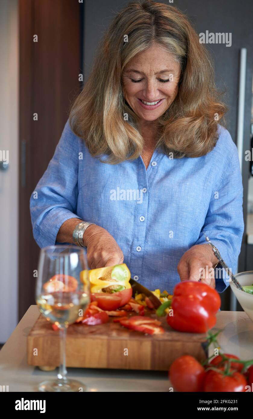 Senior woman preparing  salad in kitchen Stock Photo