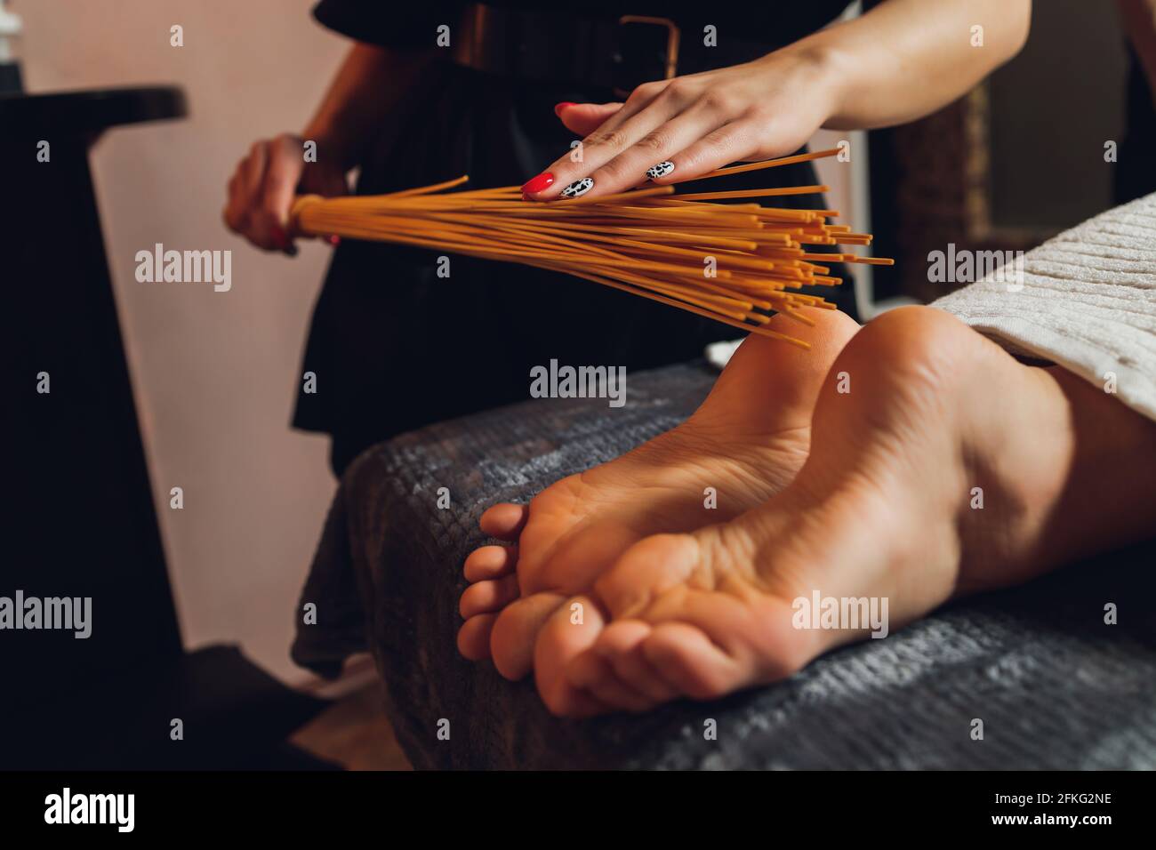 massage of female feet with bamboo sticks Stock Photo Alamy