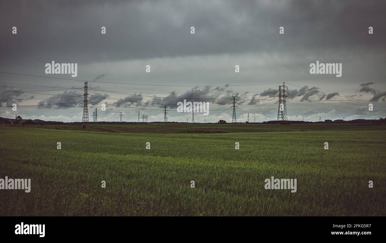 Moody sky over meadow and power lines Stock Photo