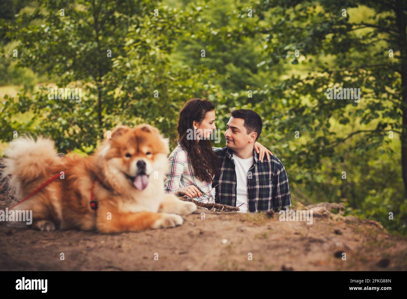 young couple and a dog in the woods. focus on couple Stock Photo - Alamy
