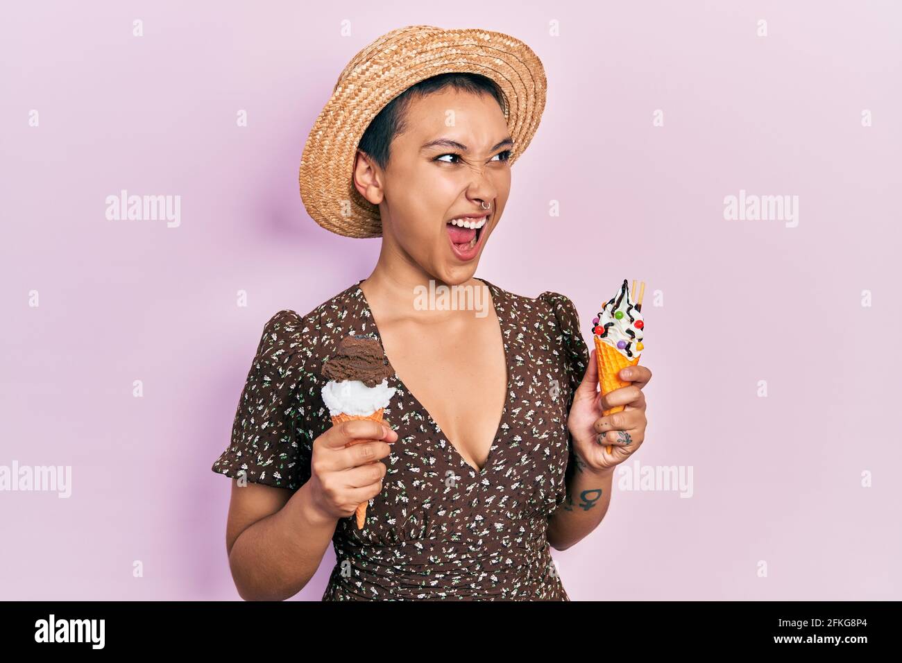 Beautiful hispanic woman with short hair eating ice cream cones angry ...
