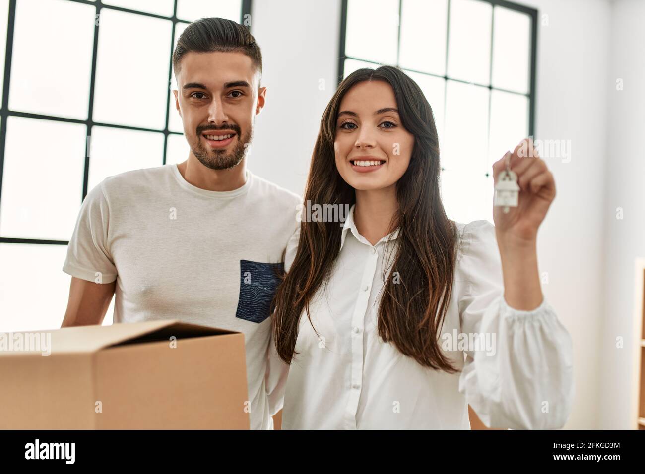 Young hispanic couple smiling happy holding cardboard boxes and key of ...