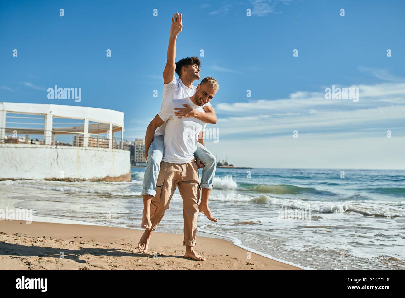 Lovely gay couple on piggyback ride at the beach Stock Photo - Alamy