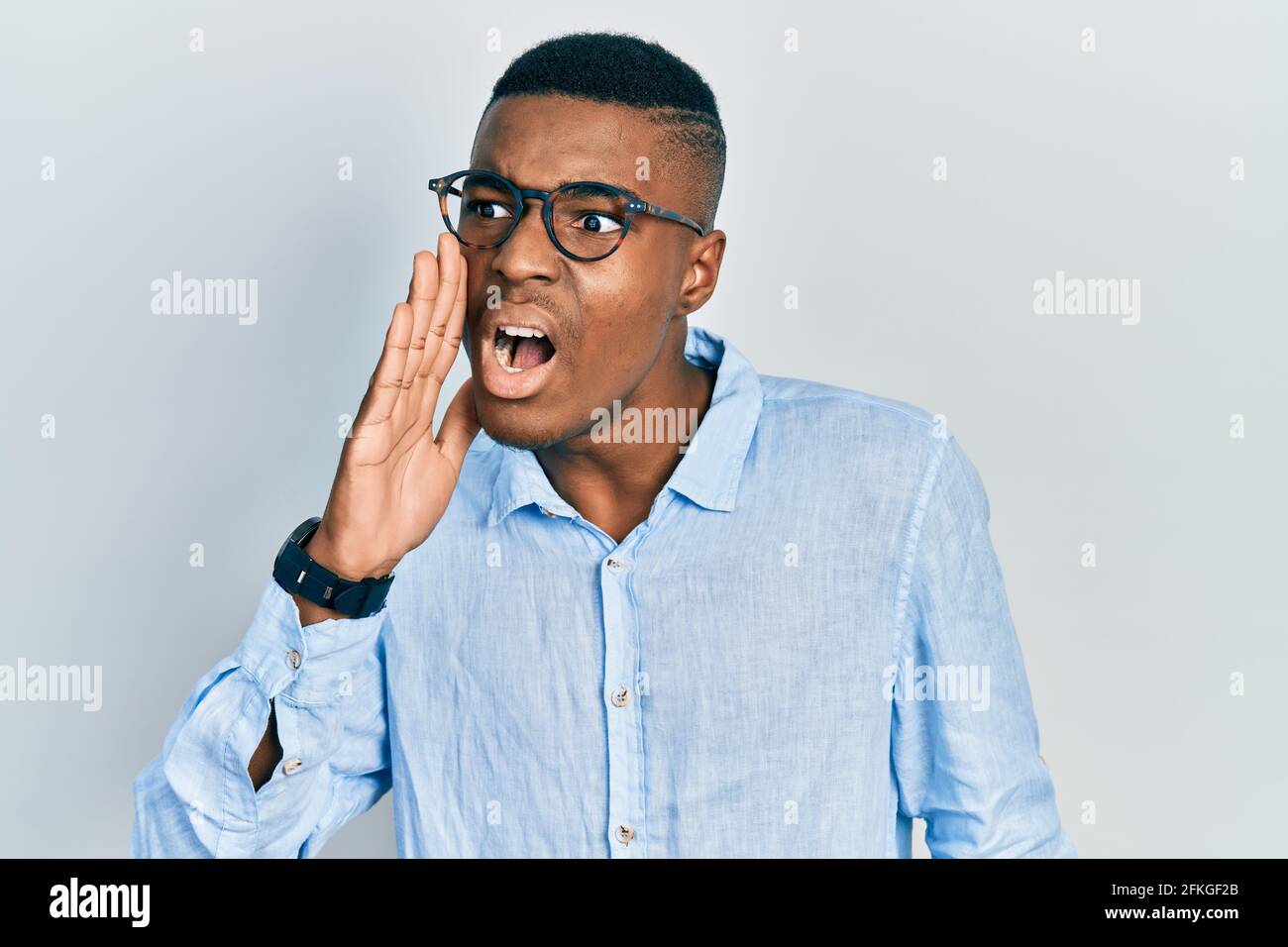 Young african american man wearing casual clothes and glasses shouting ...