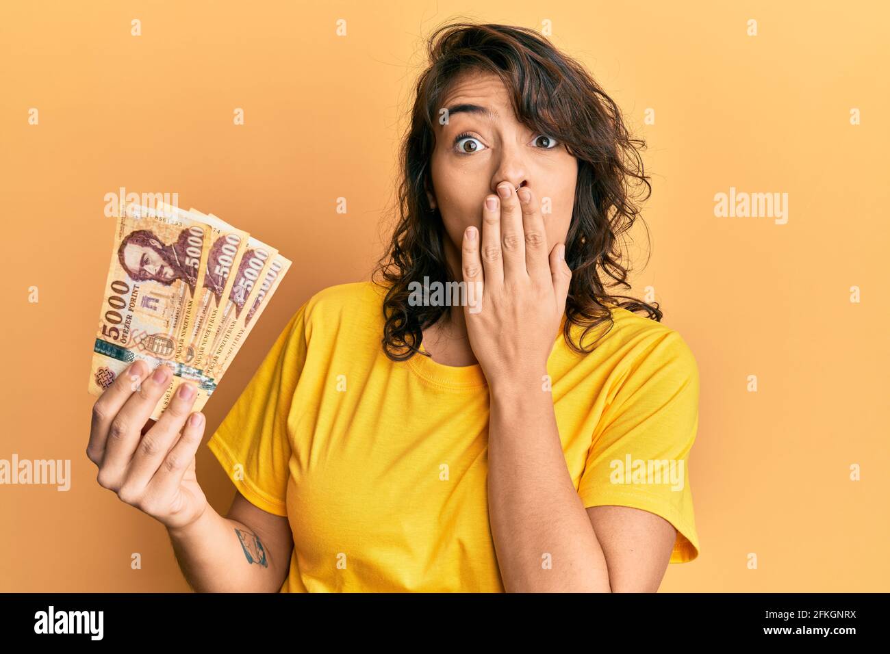 young-hispanic-woman-holding-5000-hungarian-forint-banknotes-covering