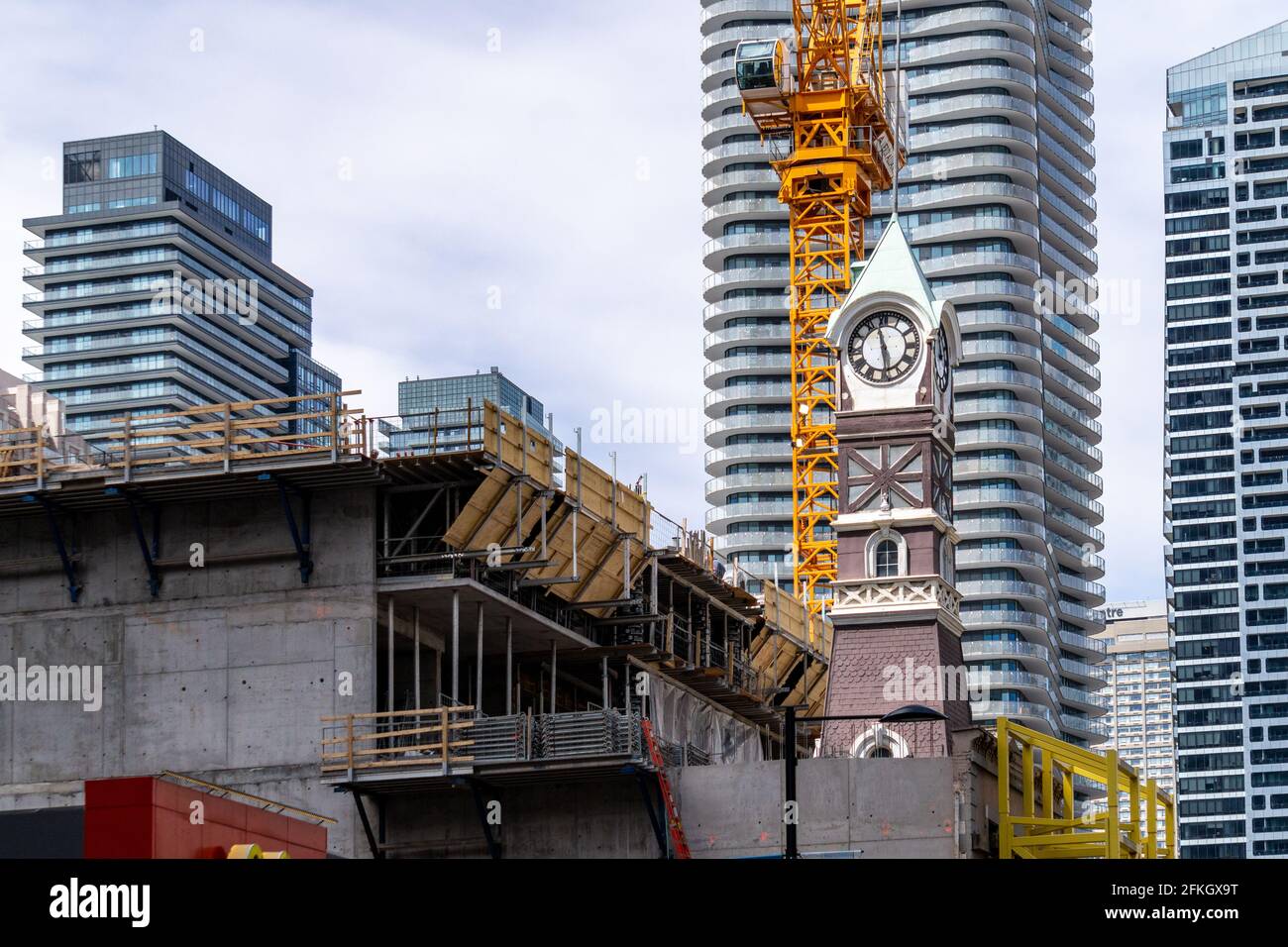 Vintage heritage clock towers of old hose-house in Yonge Street in the Toronto downtown, Canada. A new skyscraper is being built which will include th Stock Photo