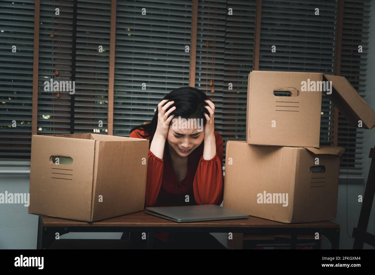 Sad Asian woman Packing belongings in a cardboard box and crying on the ...