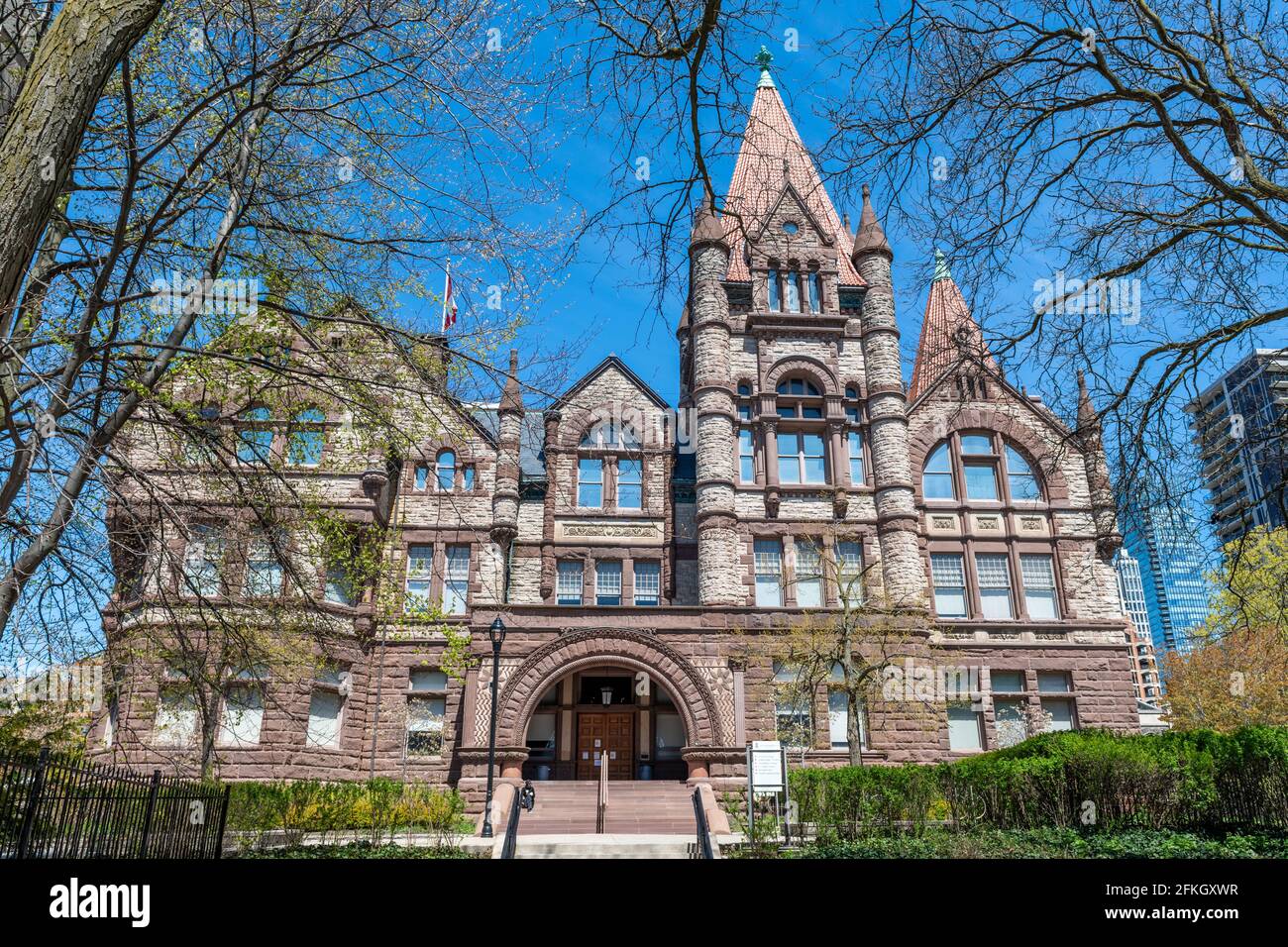 Victoria College in the grounds of the University of Toronto, Canada. The building has a Romanesque Revival architecture in red sandstone walls Stock Photo