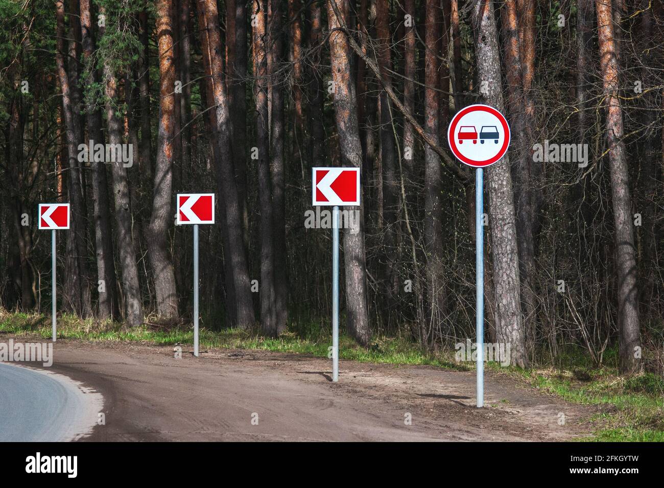 No passing road sign on winding road in the forest Stock Photo