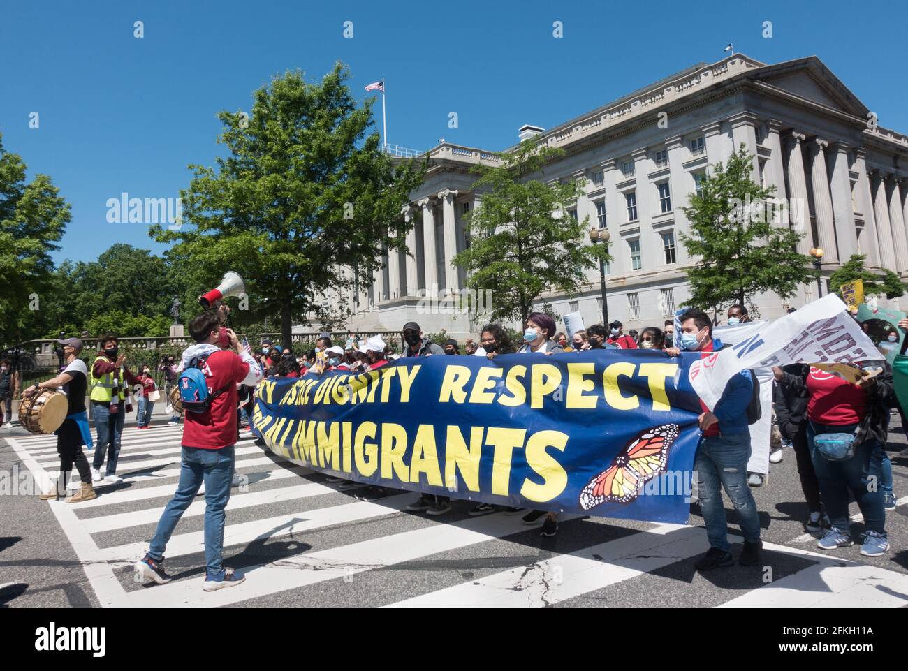 Demonstrators demanding the Biden administration make progress on immigration reform march past the Treasury Department as they head to a rally on the National Mall on May Day, known as International Workers Day.  More than 25 groups participated in the march, which originated at Black Lives Matter Plaza near the White House. May 1, 2021, Washington, DC Stock Photo