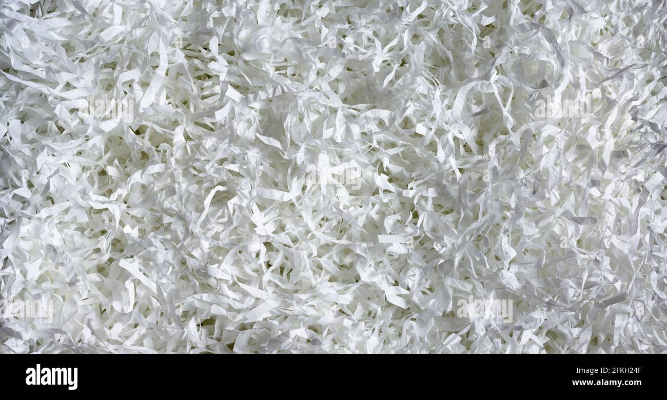 Shredded paper texture background, top view of many white paper strips. Pile of cut paper like confetti for party or box filler for shipping fragile i Stock Photo