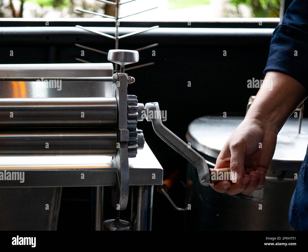 https://c8.alamy.com/comp/2FKH751/womans-hands-holding-the-dough-sheeter-in-the-kitchen-2FKH751.jpg