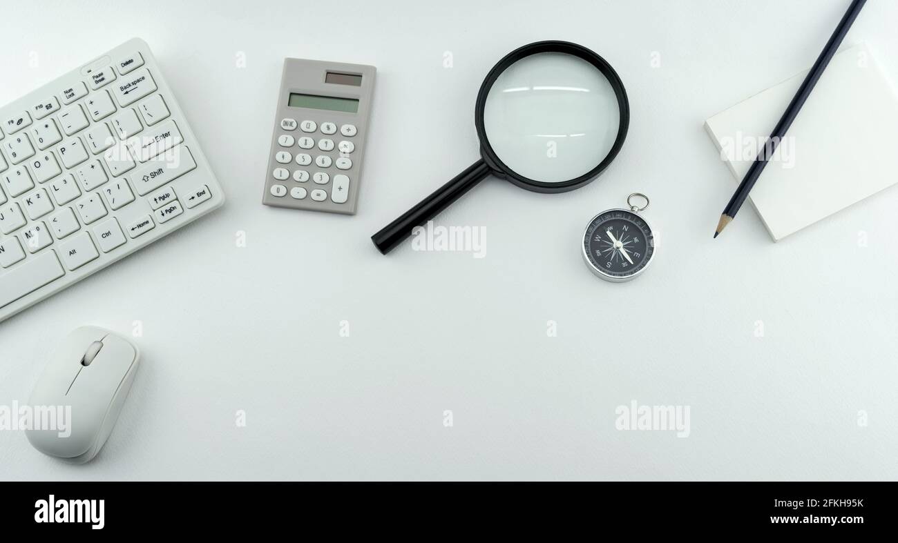 Business objects of Pc,keyboard,mouse,pencil,compass and calculator,Magnifying glass on White table background. Stock Photo