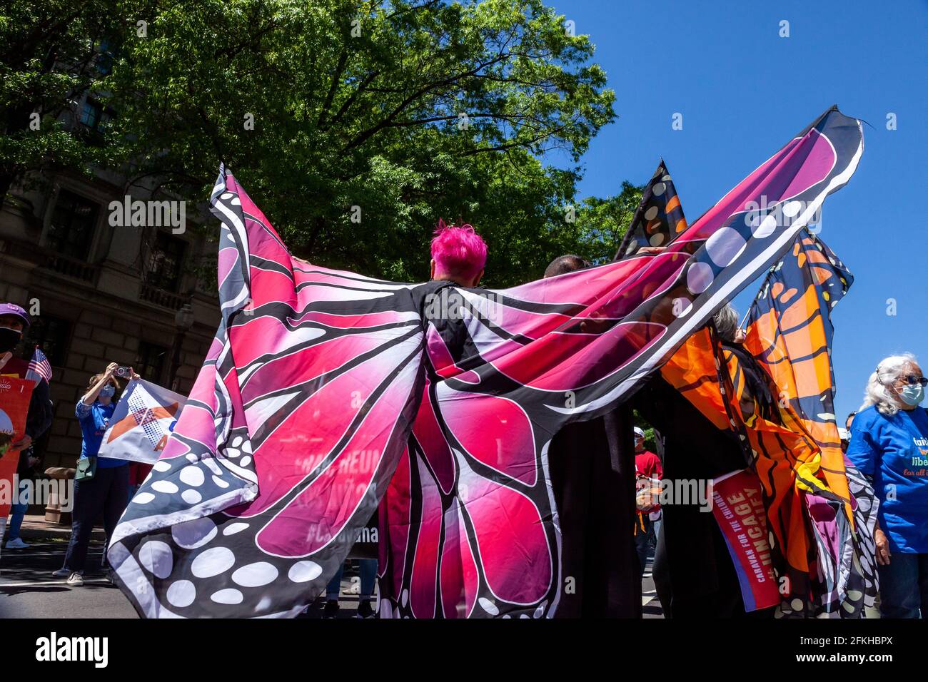 Washington, DC, United States, 1 May, 2021.  Pictured: Ani Rivera wears pink butterfly wings while marching with Caravana para Los Niños (Caravan for the Children) during a large march for immigrant rights and citizenship.  Credit: Allison C Bailey / Alamy Live News Stock Photo