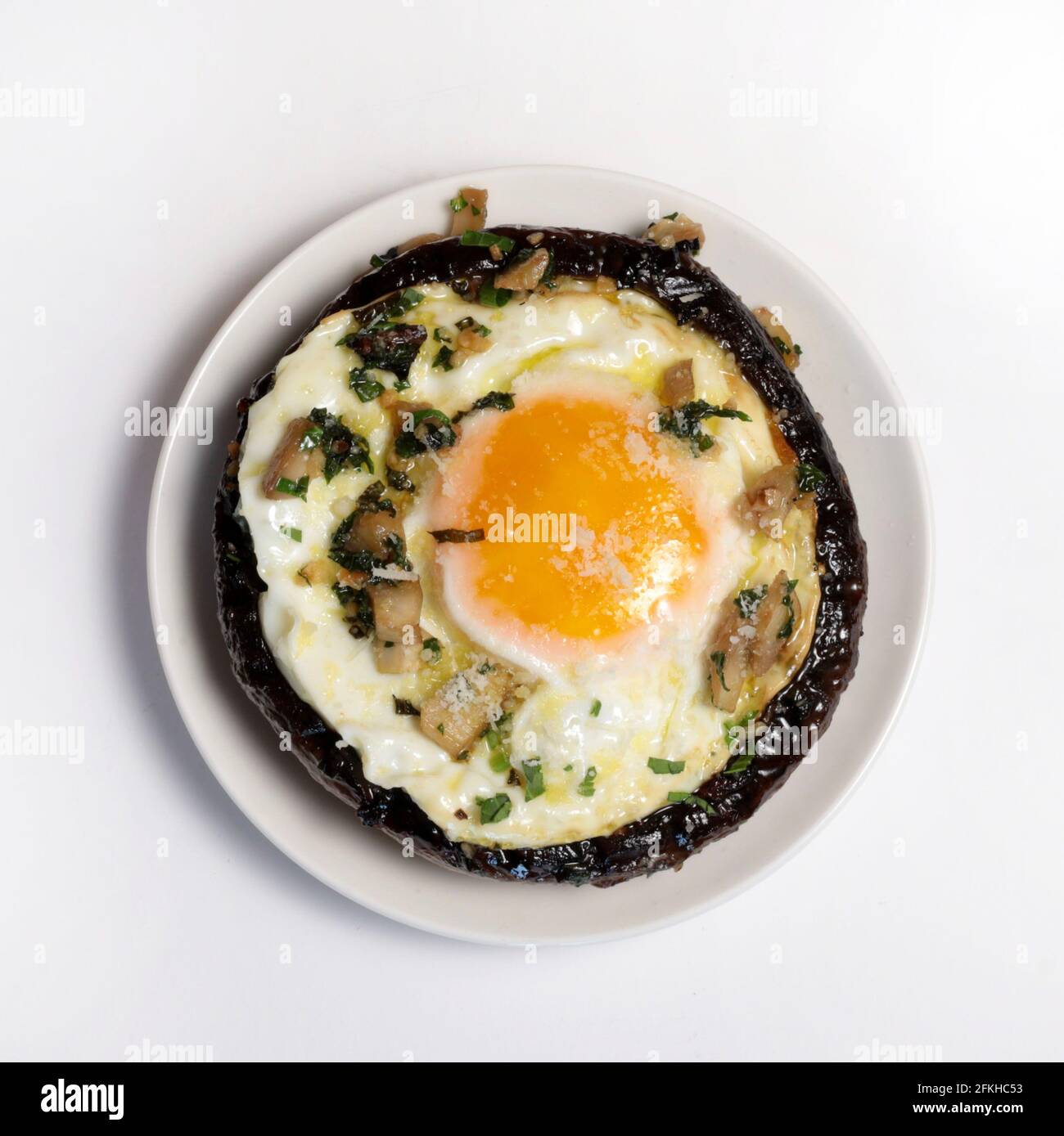 Stuffed portobello mushrooms with fried egg isolated on white