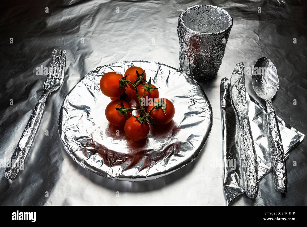 home plate, crockery and a glasscovered with aluminum foil with some