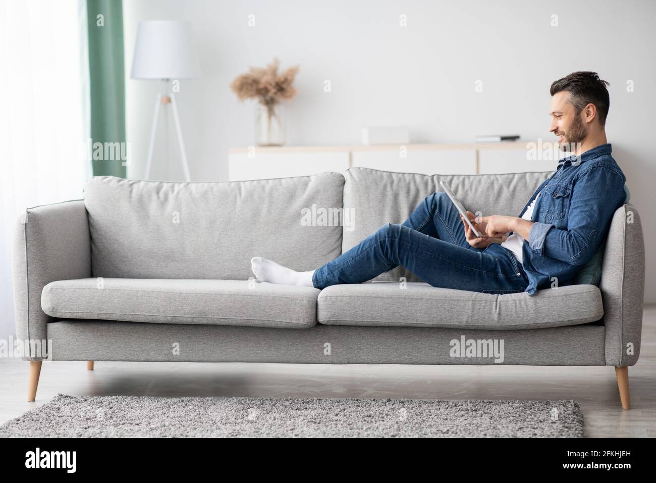 Handsome bearded man using digital tablet at home Stock Photo