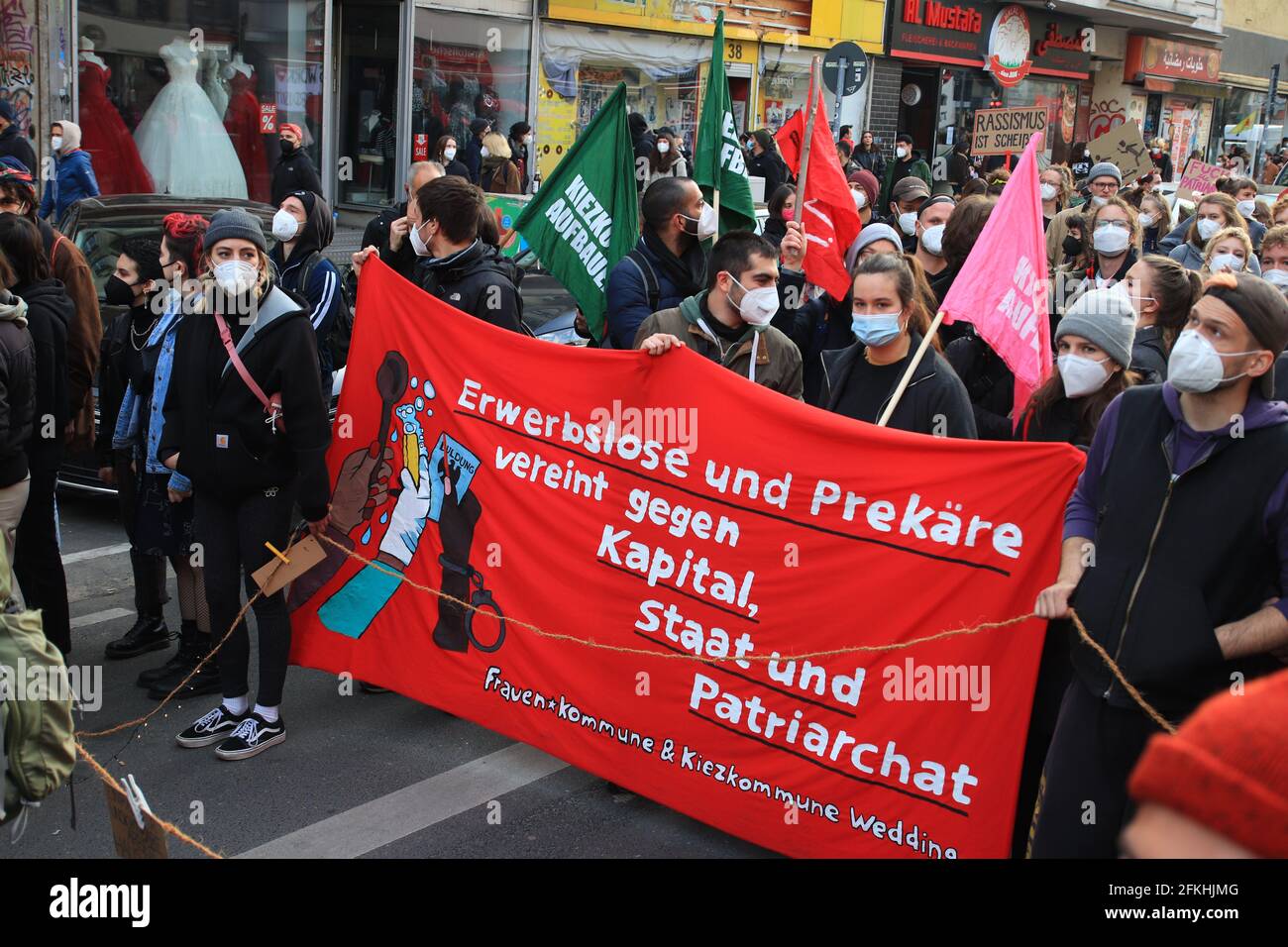 Berlin, Germany - May 01, 2021: Protesters holding a banner with the slogan ' Unemployed and precarious united against capital, state and patriarchy' Stock Photo