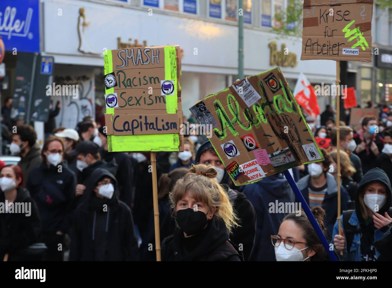 Berlin, Germany - May 01, 2021: A protester holding a placecard saying 'Smash Racism Sexism Capitalism' 1st May Demonstrations on the streets of Berli Stock Photo