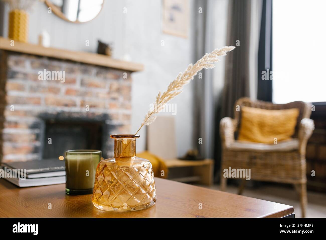 A vase of dried flowers on the table. Scandinavian classic room with wooden details and a brick fireplace, minimalistic interior design. a real photo. Stock Photo