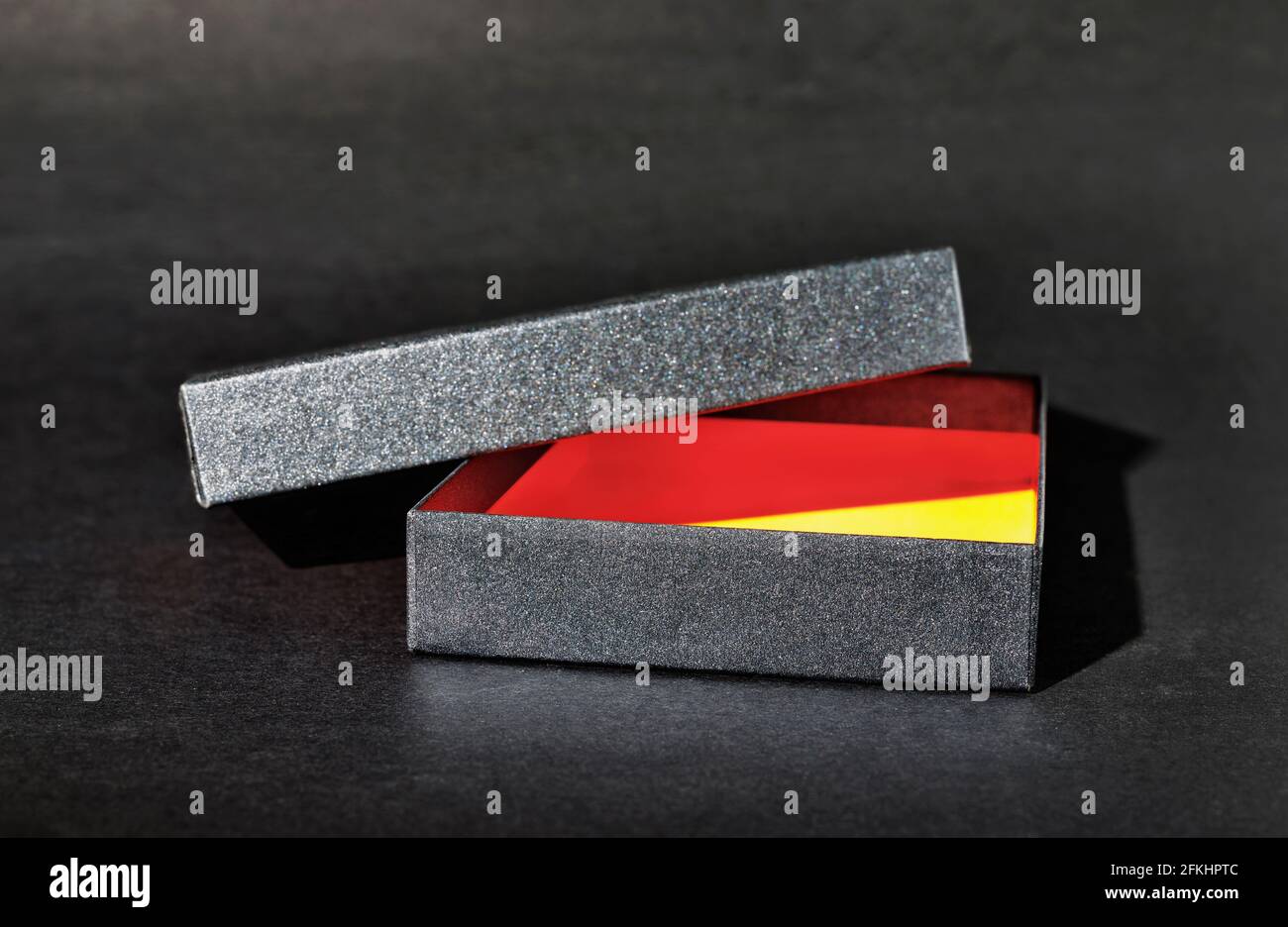 Opened empty black gift box on black background , black lid on box , Stock Photo