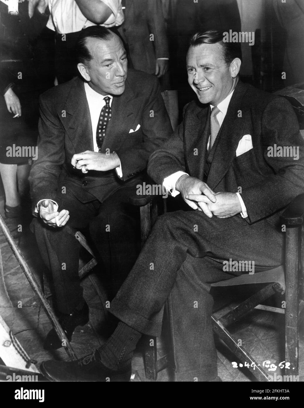 NOEL COWARD with Set Visitor JOHN MILLS on set candid during filming of THE ASTONISHED HEART 1950 directors ANTONY DARNBOROUGH and TERENCE FISHER play / screenplay Noel Coward Gainsborough Pictures / Sydney Box Productions / General Film Distributors (GFD) Stock Photo