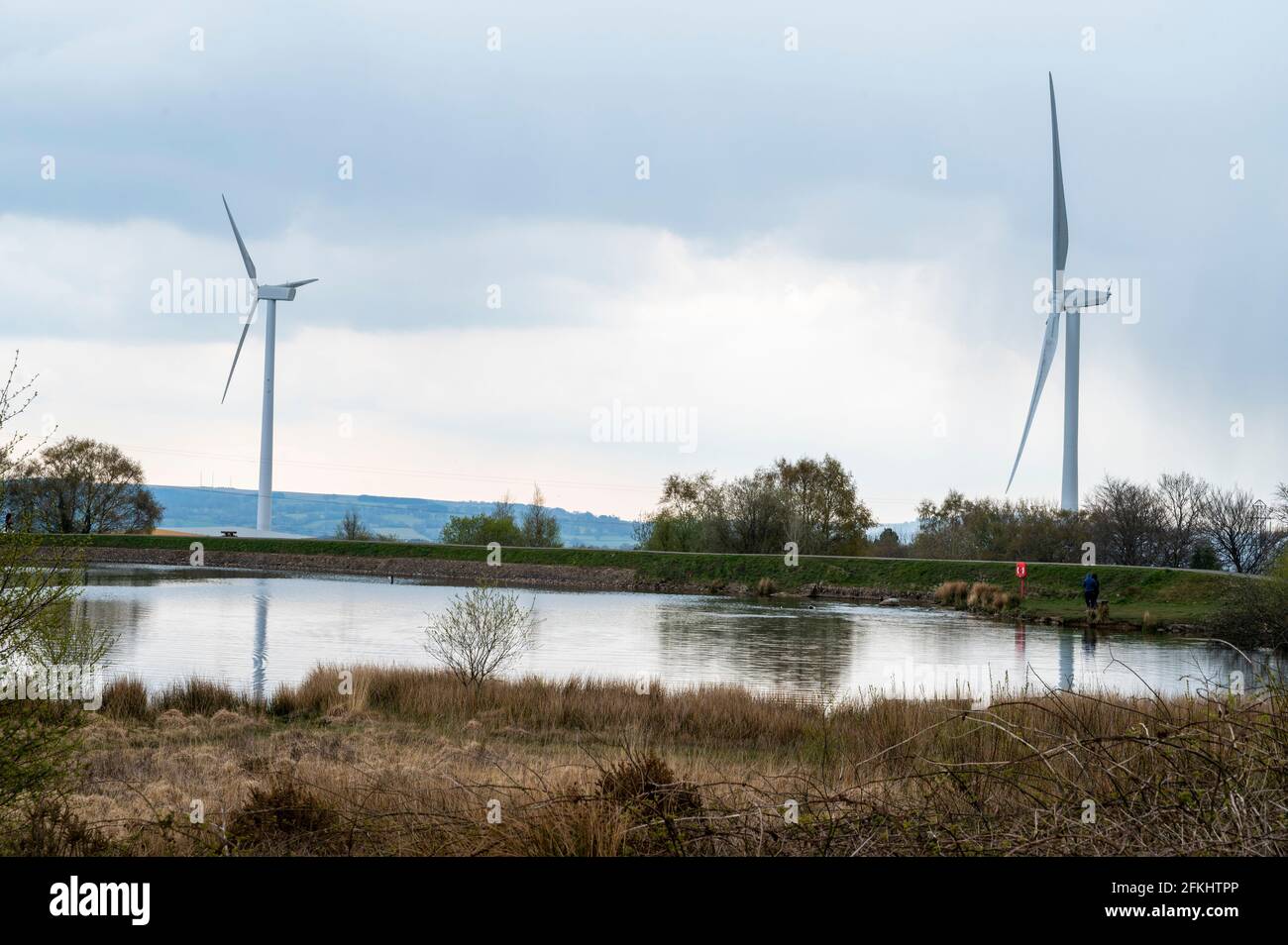 Wind turbines reach into the sky at Pen-y-fan Pond Country Park, near Blackwood, South Wales. Stock Photo