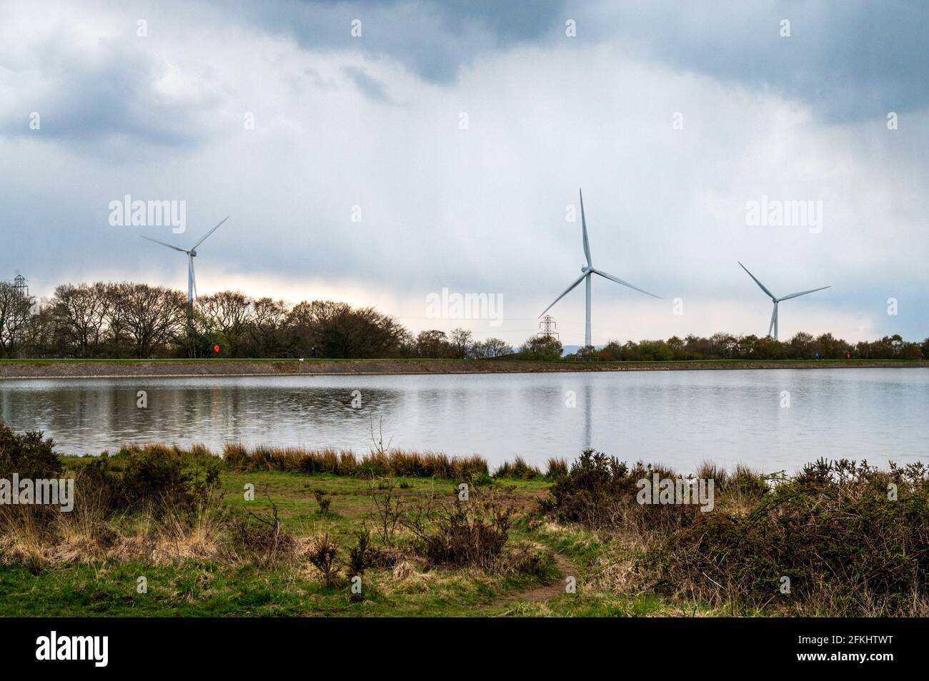 Wind turbines reach into the sky at Pen-y-fan Pond Country Park, near Blackwood, South Wales. Stock Photo