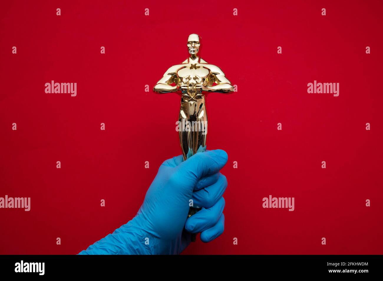 Movie and entertainment award held by someone wearing protective gloves Stock Photo