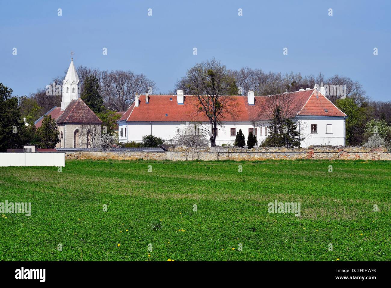 Austria, the parish church of Margarethen am Moos is surrounded by a Romanesque charnel house from 1233, a former monastery - now parsonage and an old Stock Photo