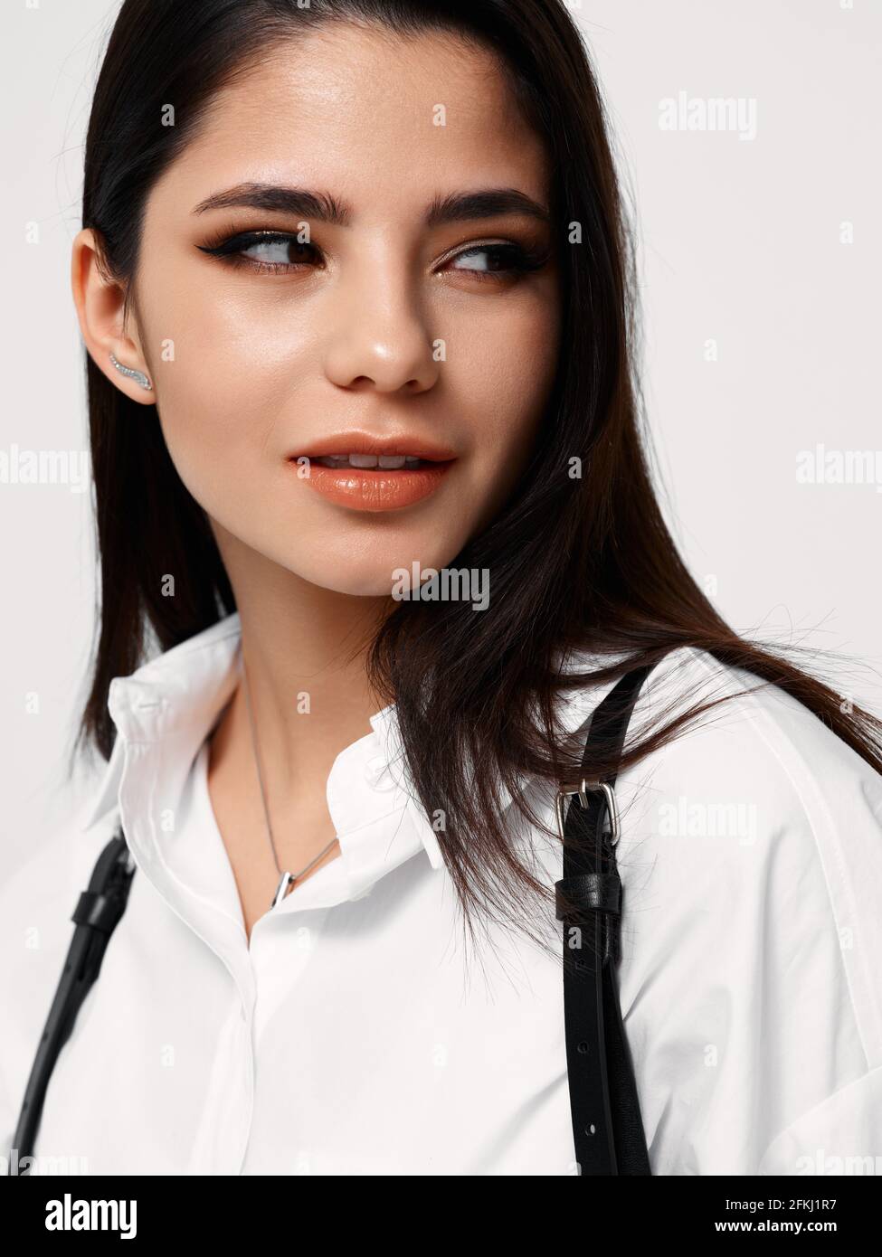 brunette woman in white shirt looks to the side Stock Photo - Alamy