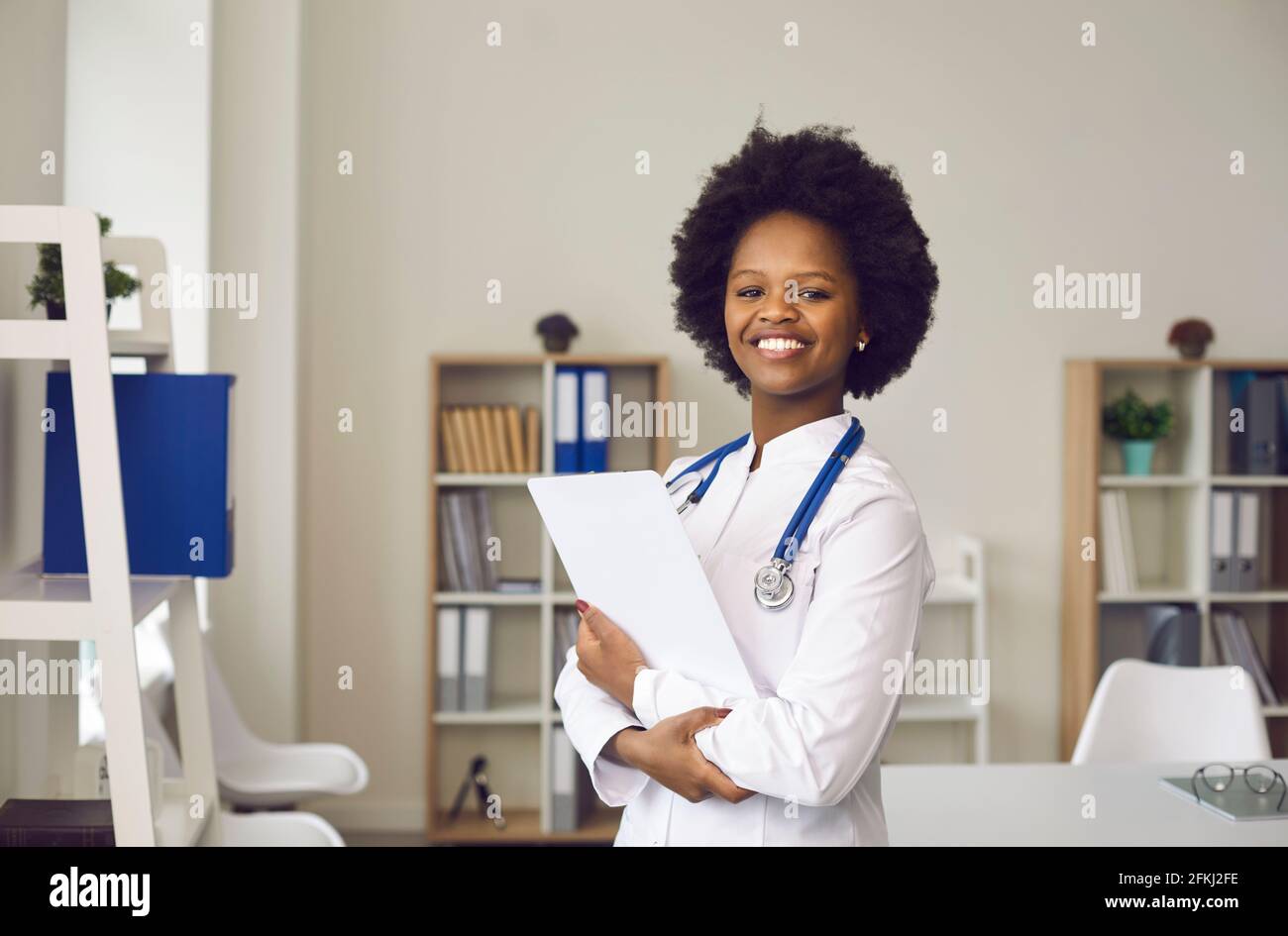 Smiling young african american doctor in uniform with paper in hand portrait Stock Photo