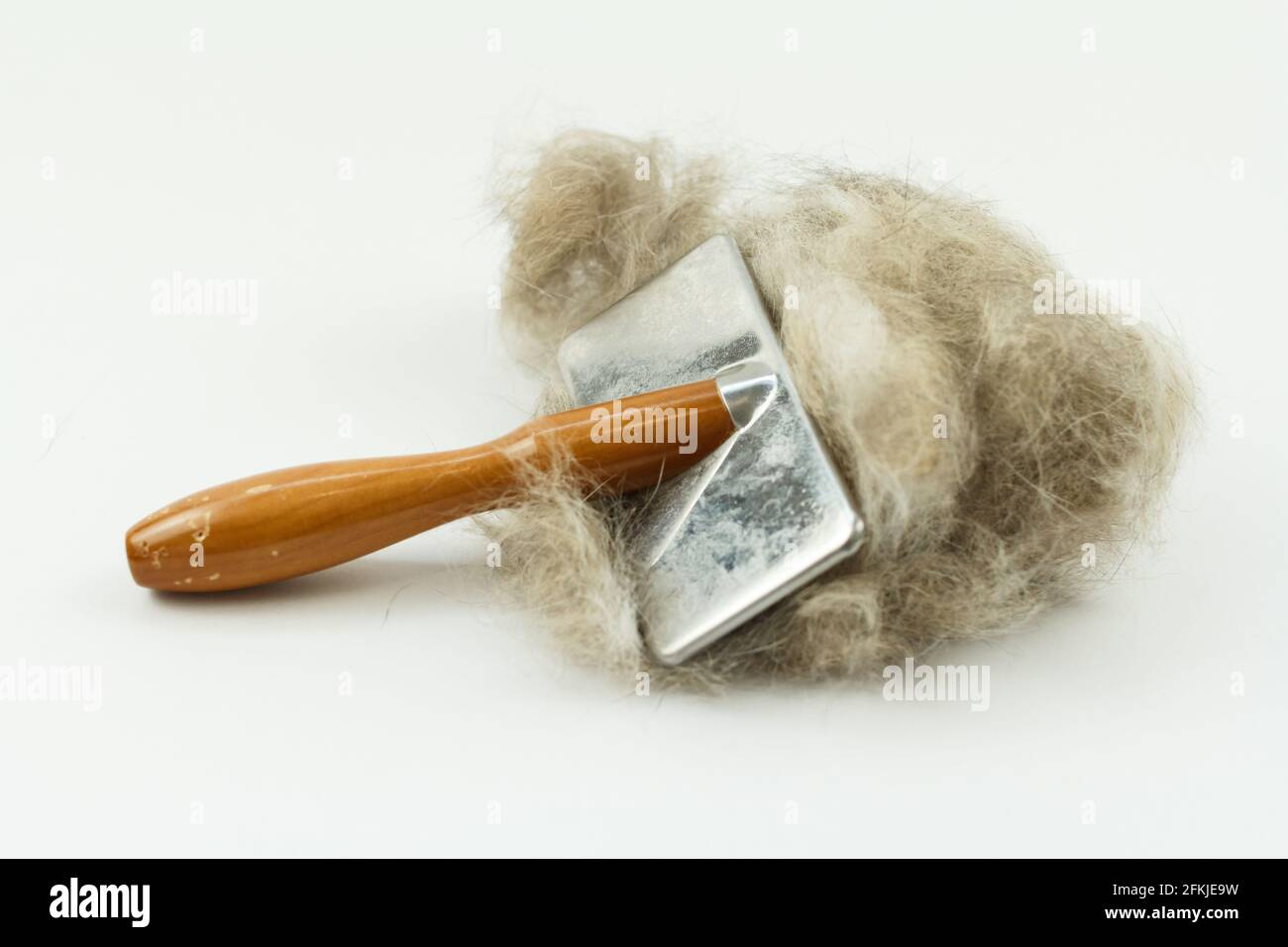 Cat brush with cat hair clump isolated on white, Long hair cat
