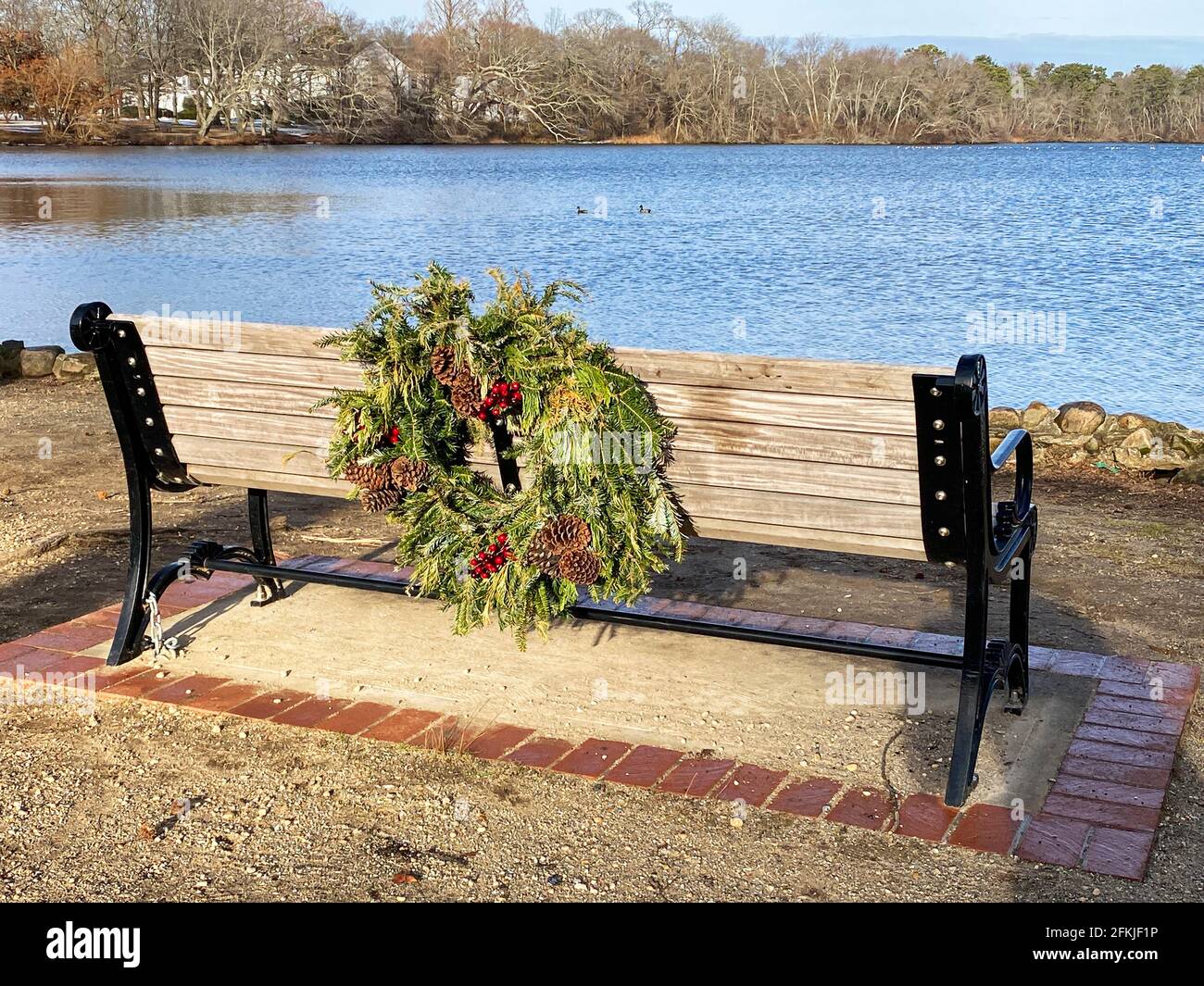 Belmont lake state park bench with a holiday wreath on the back overlooking the lake in December. Stock Photo