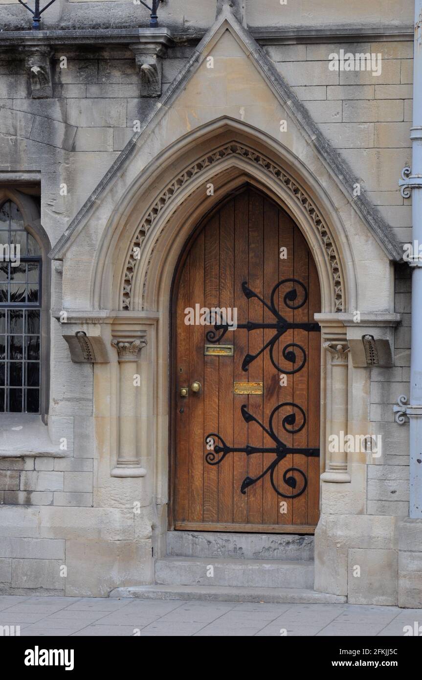 View of english gothic building facade with ogival arched wooden door and intricate architectural detailing from Oxford High Street, Oxford, United Ki Stock Photo