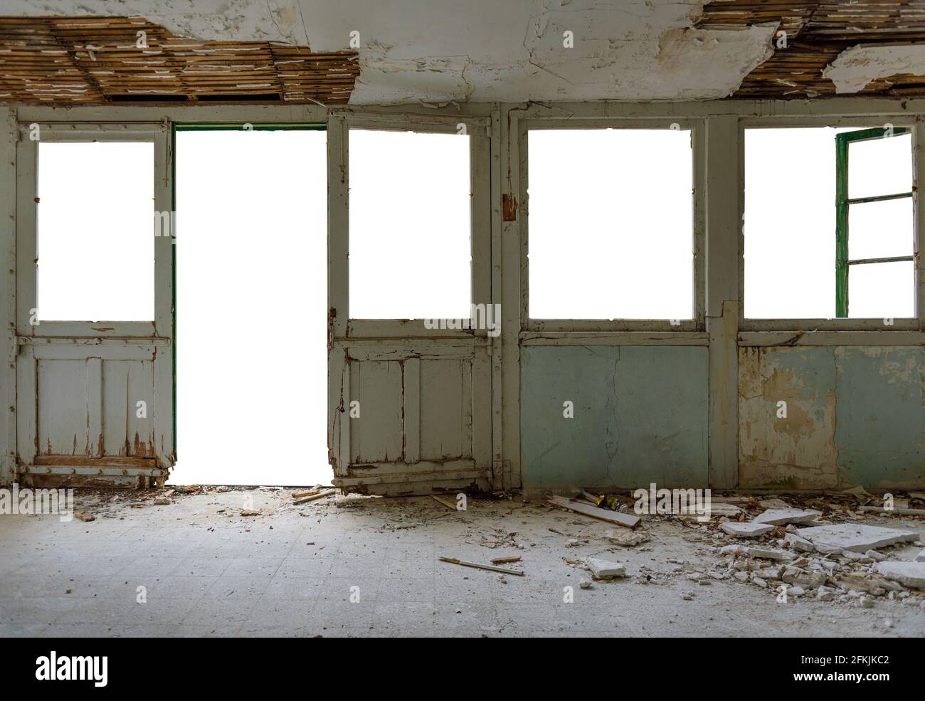 Isolated abandoned house interior. Gallery with door and window frames, broken glass and fallen plaster, cut out view outside Stock Photo